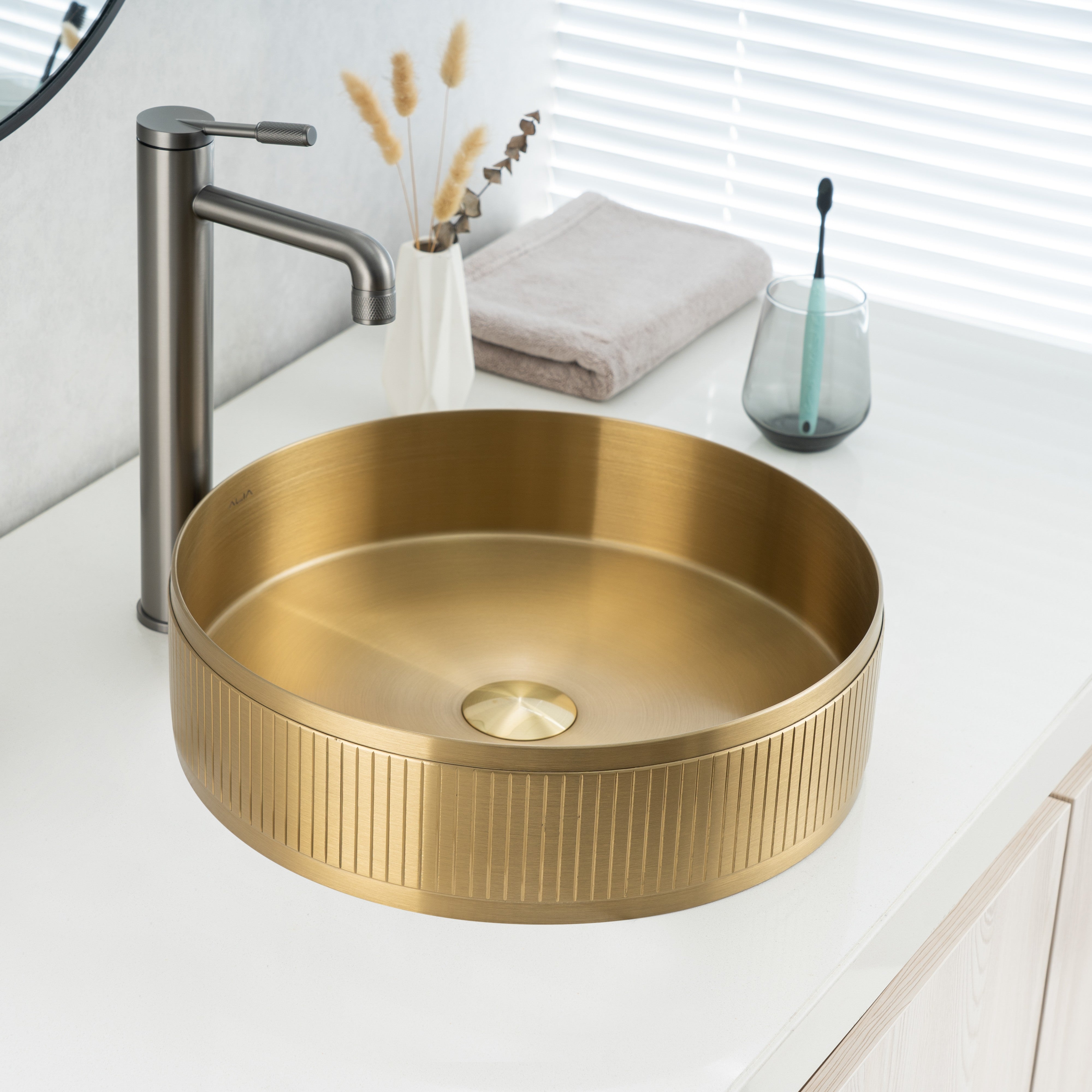 Real photo of ALIA textured brushed gold basin installed above-counter, showcasing its soft shimmer and refined grain texture.