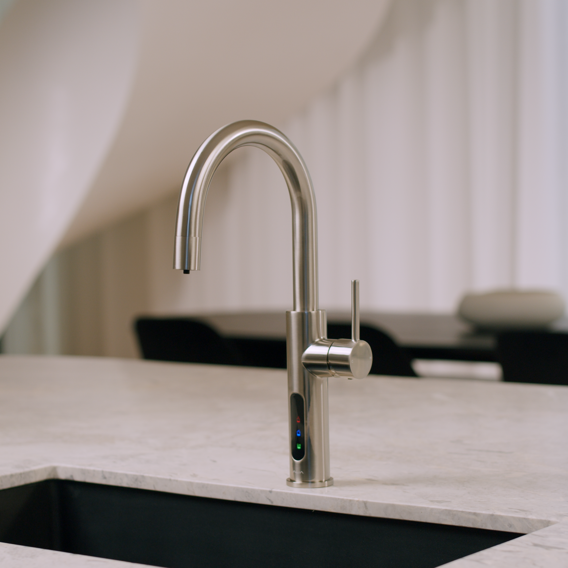 Alia X51 instant hot, cold, and sparkling filtered water tap in brushed nickel finish installed in a designer kitchen, emphasizing both functionality and chic water filtration solutions.