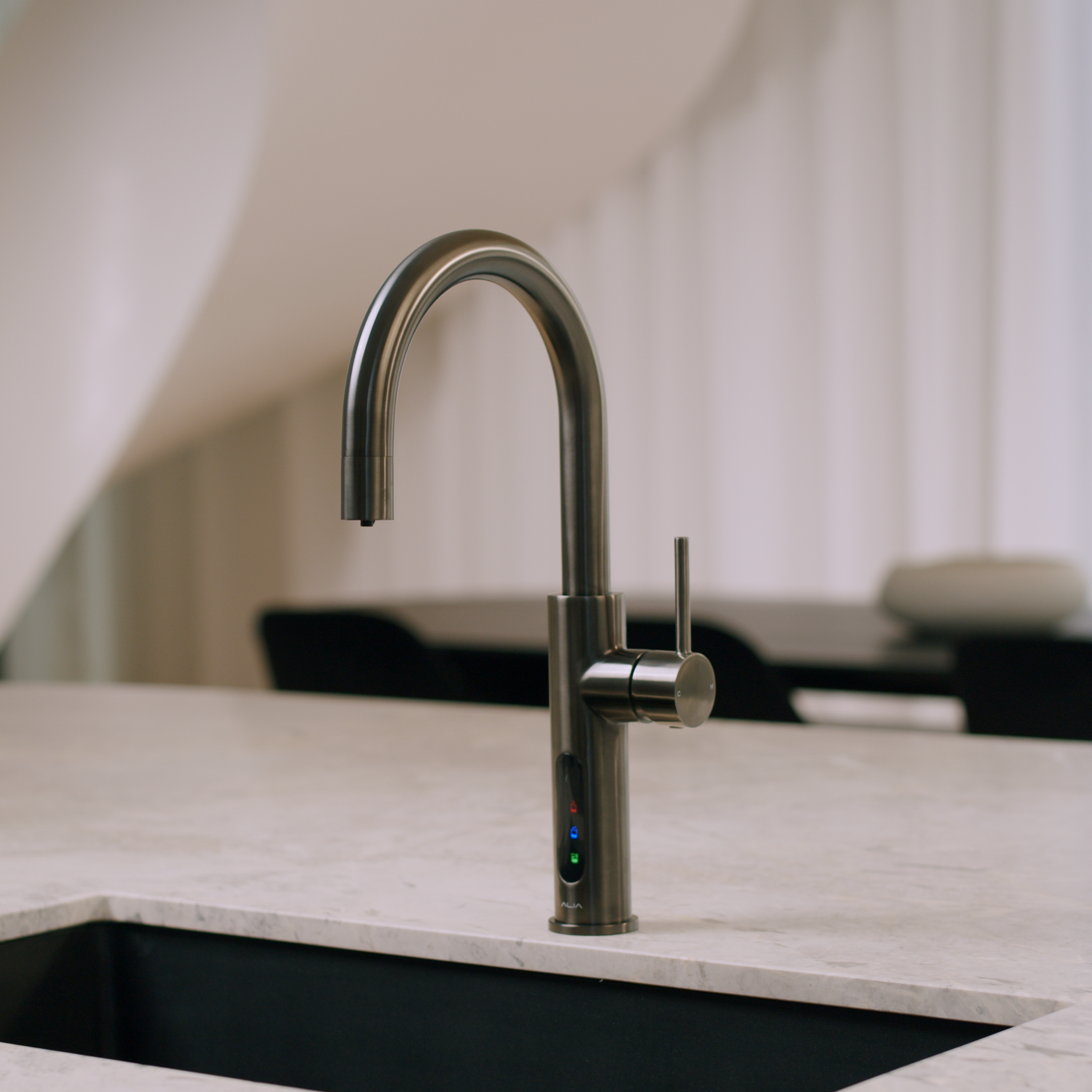 Alia X51 instant hot, cold, and sparkling filtered water tap in gunmetal grey finish showcased in a contemporary kitchen, providing filtered water with a bold modern style.