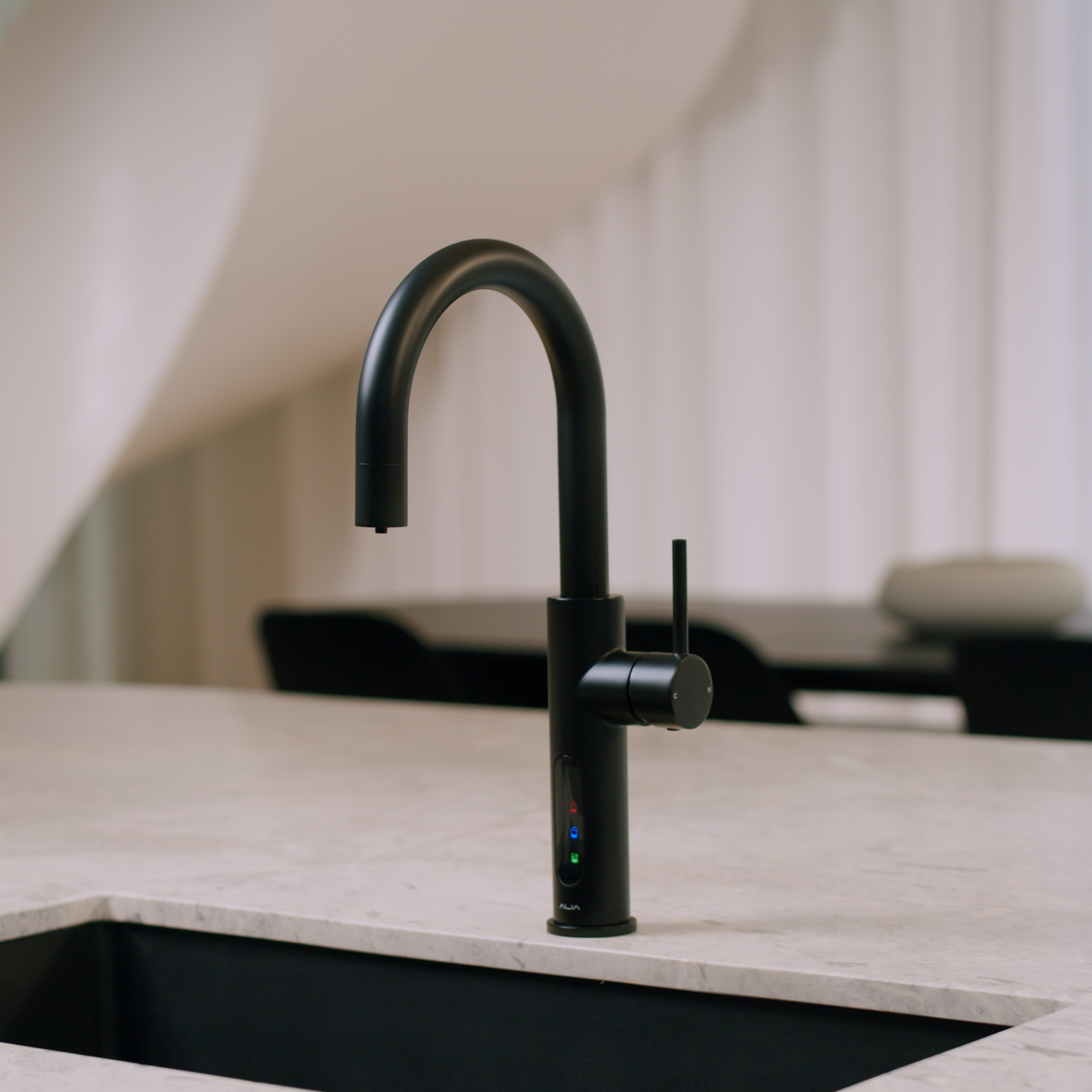 Alia X51 instant hot, cold, and sparkling filtered water tap in matte black accenting a luxury kitchen, highlighting its premium filtered water and bold contemporary design.