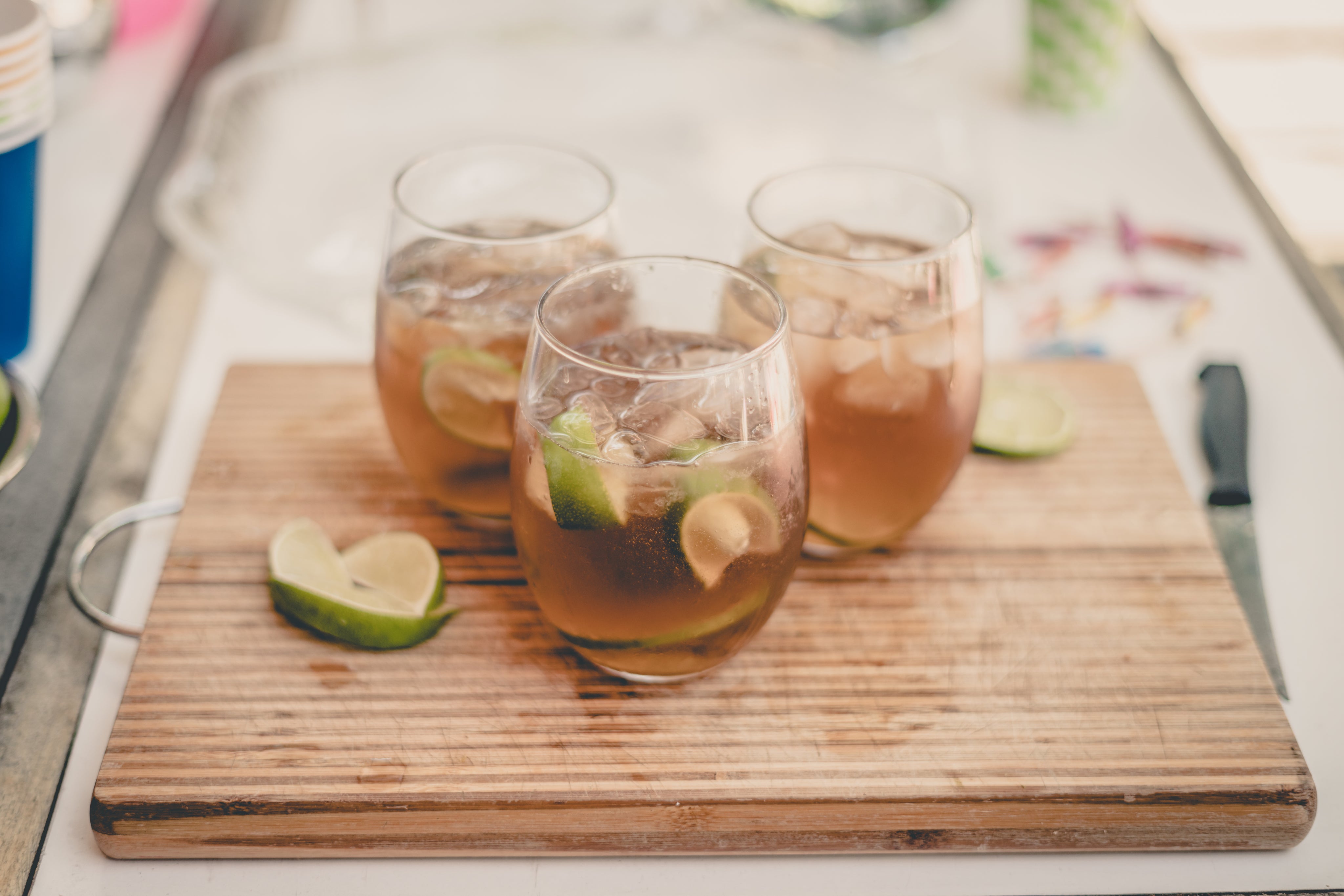 Glasses of sparkling water cocktails with fresh lime slices on a counter, highlighting the sparkling water dispenser tap collection for home drink mixing. Perfect for preparing bar-quality cocktails and mocktails straight from your filtered tap water system.