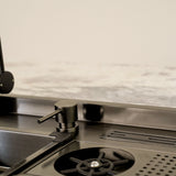 Elegantly designed ALIA Smart Sink displayed in a sophisticated kitchen, highlighting the integrated soap dispenser, high-pressure cup washer, compact waste bin, and knife rack with drain.