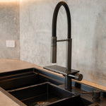Modern kitchen scene featuring the ALIA Smart Sink with dual bowls, progressive 360° rotating pull-out mixer tap, and waterfall function for advanced usability and style.