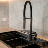Modern kitchen scene featuring the ALIA Smart Sink with dual bowls, progressive 360° rotating pull-out mixer tap, and waterfall function for advanced usability and style.