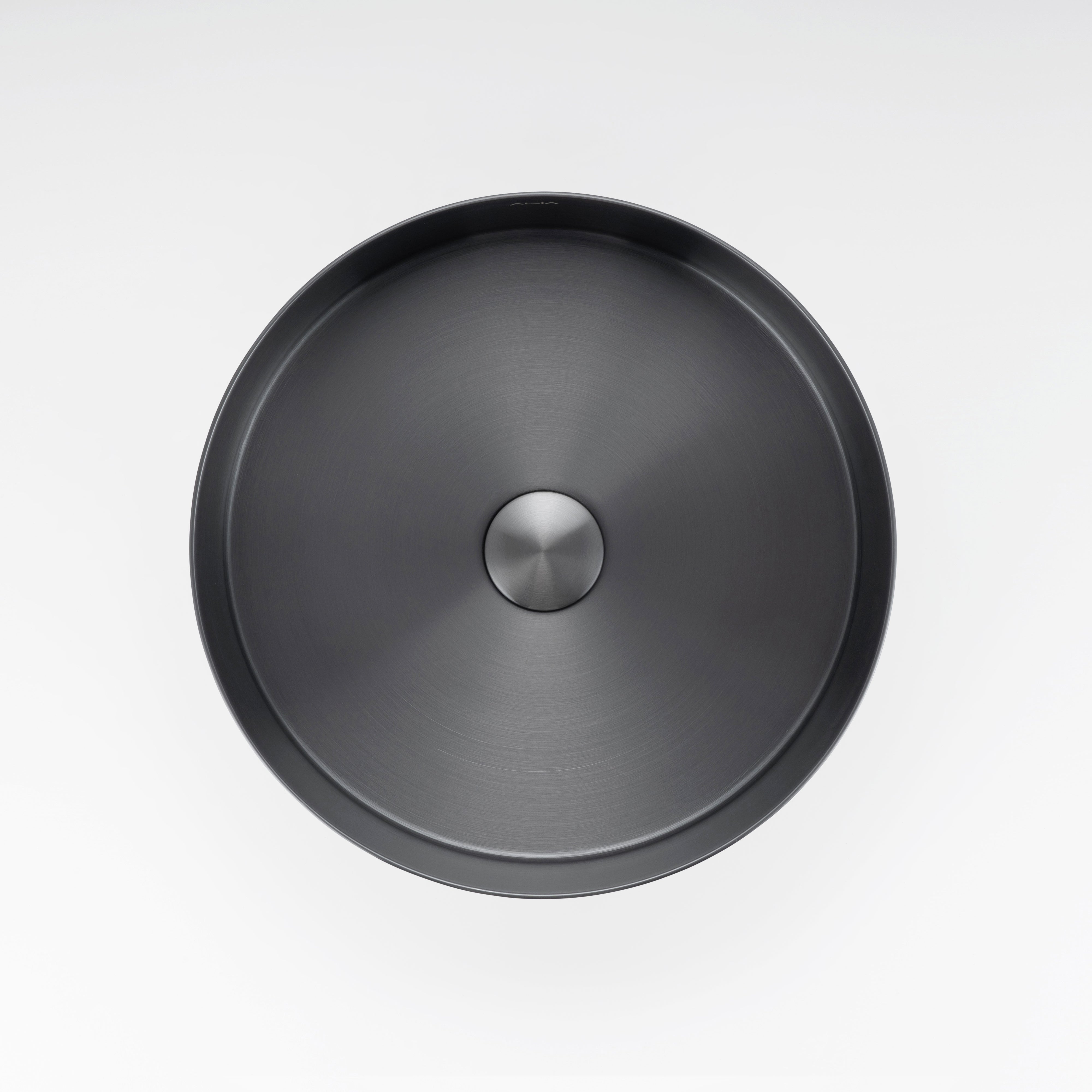 ALIA gunmetal grey stainless steel basin combines durability and contemporary aesthetics for modern bathrooms. Round black sink with a silver drain on a white background.