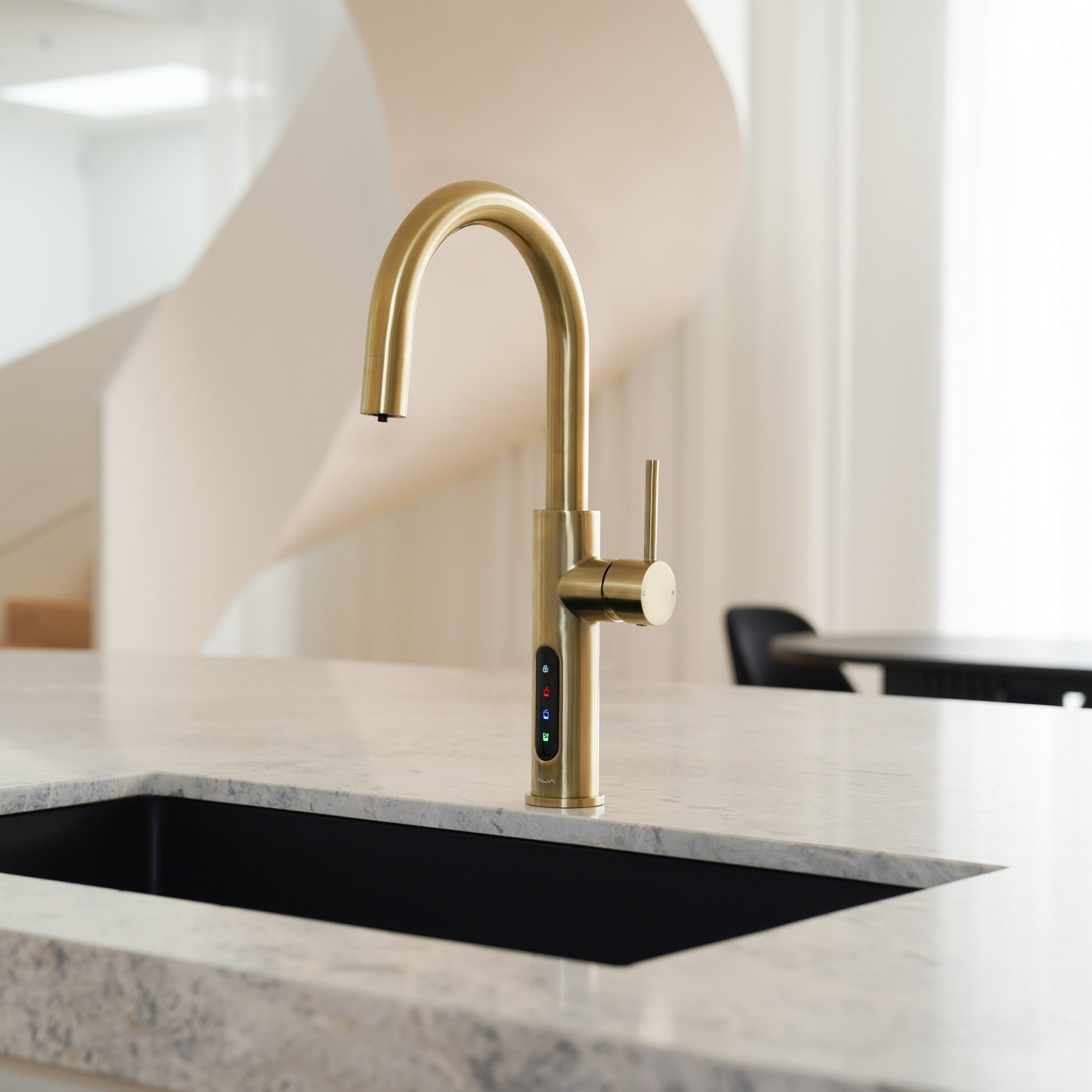 Alia X51 instant hot, cold, and sparkling filtered water tap in brushed gold finish, featured in a luxury kitchen setting, delivering pure filtered water with a touch of opulence.