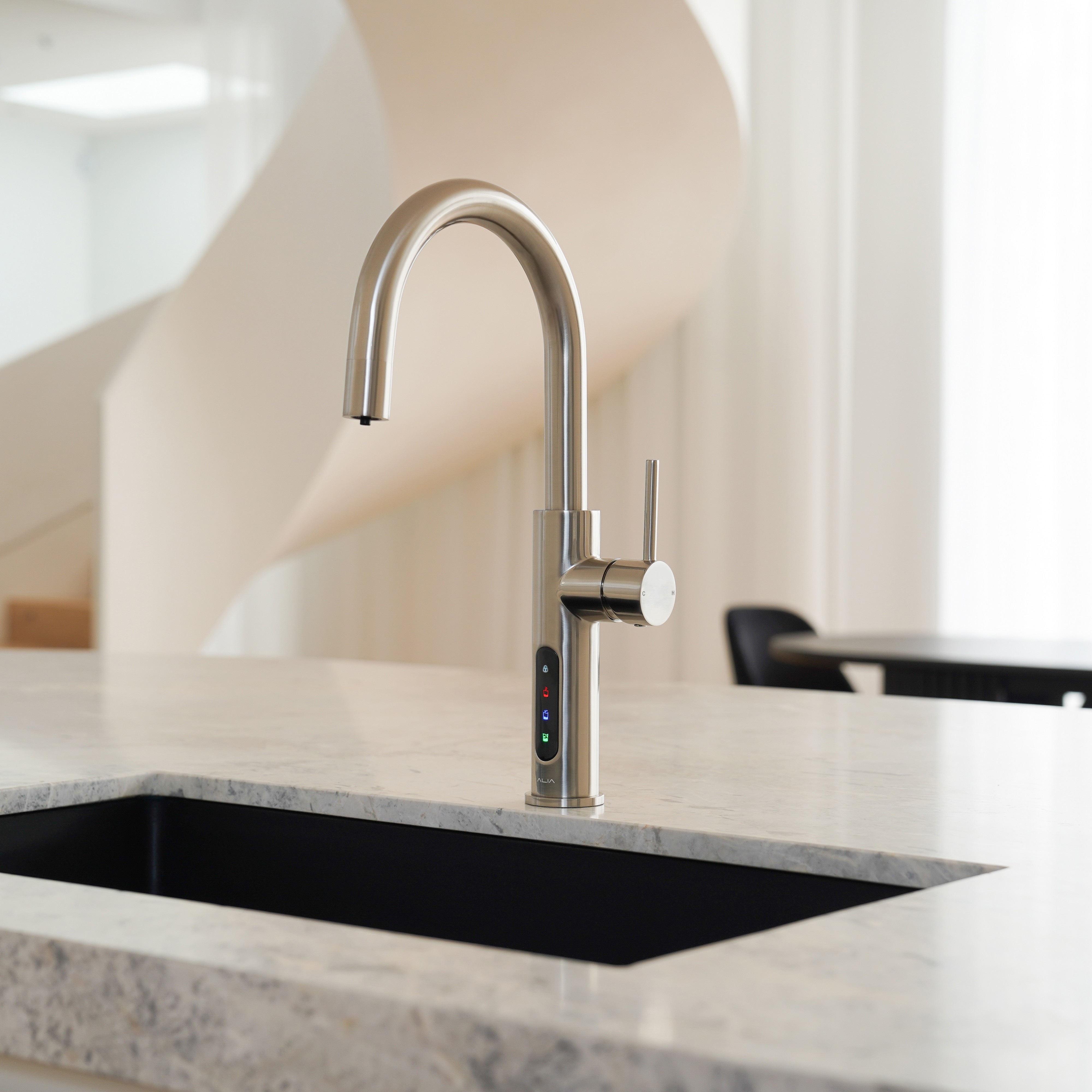 Alia X51 instant hot, cold, and sparkling filtered water tap in brushed nickel finish installed in a designer kitchen, emphasizing both functionality and chic water filtration solutions.