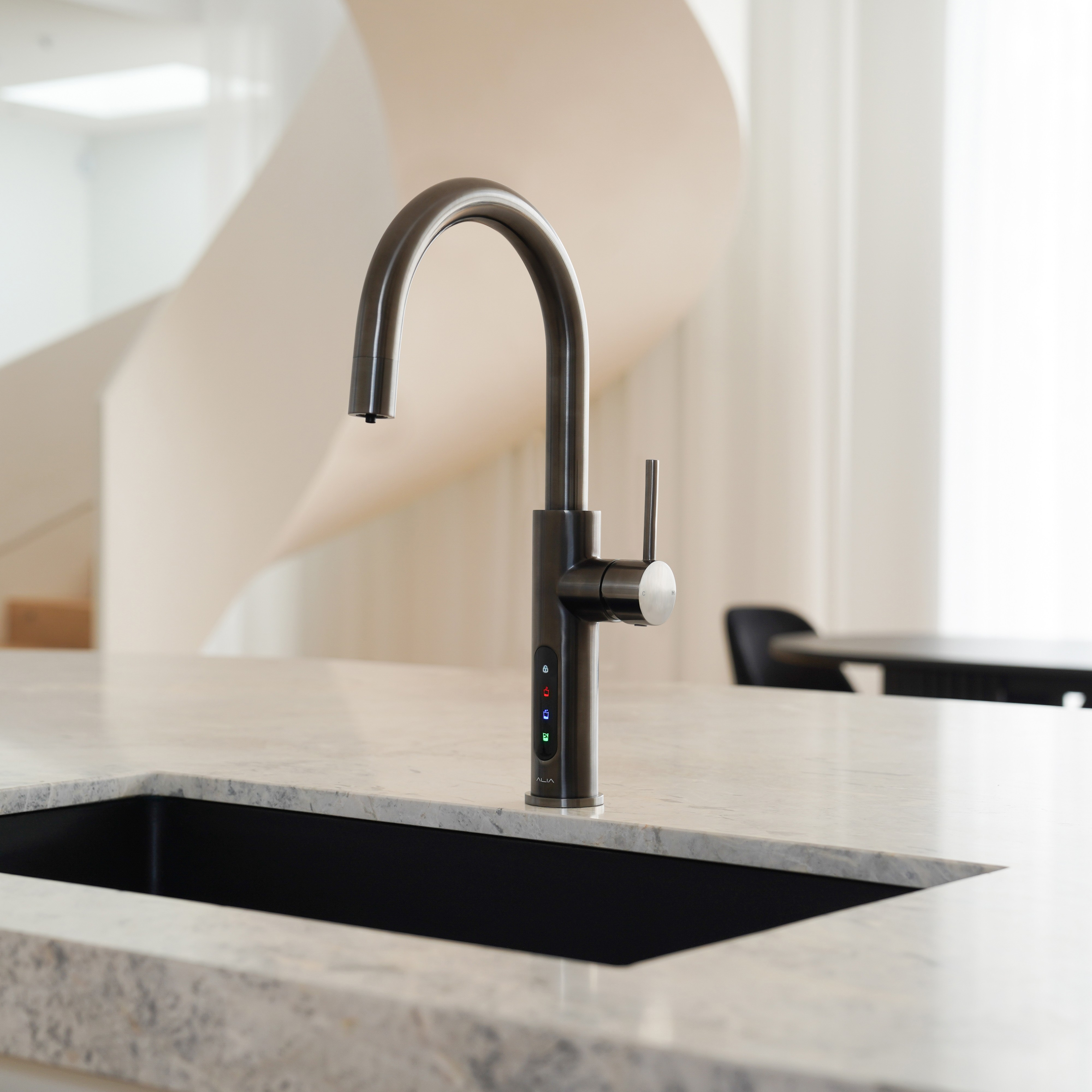 Alia X51 instant hot, cold, and sparkling filtered water tap in gunmetal grey finish showcased in a contemporary kitchen, providing filtered water with a bold modern style.