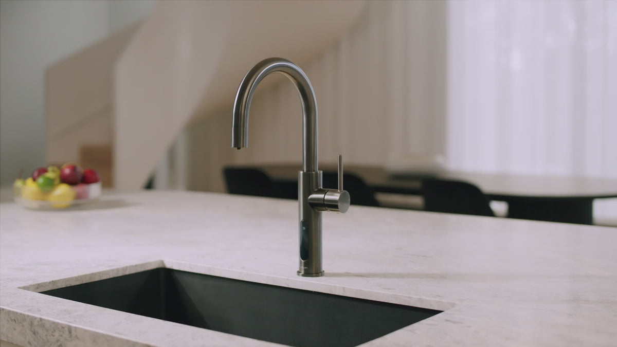 ALIA smart kitchen tap with touch-sensitive controls dispensing sparkling and chilled water, shown in chrome and brushed gold finishes